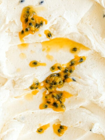 Passion fruit buttercream shown up close, fresh granadilla has been drizzled over the frosting.