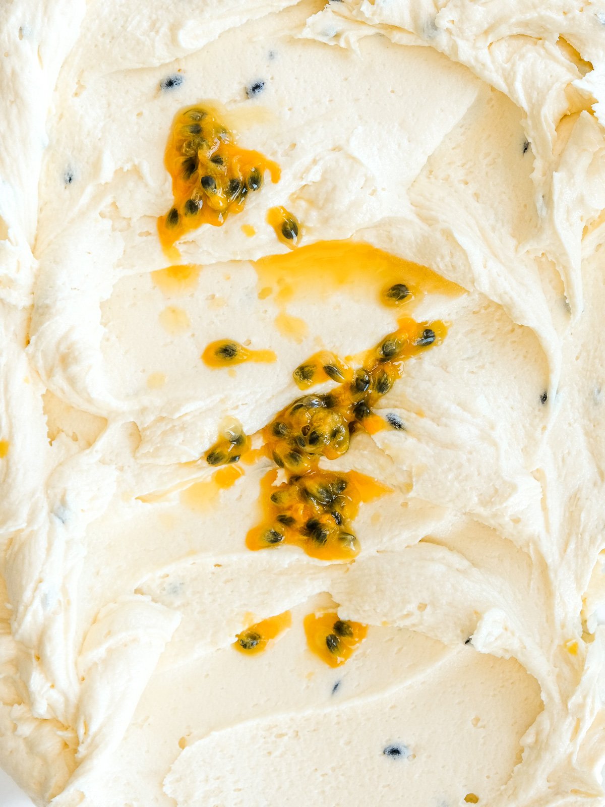 Image shows the buttercream up close, it has been drizzled with fresh granadilla.