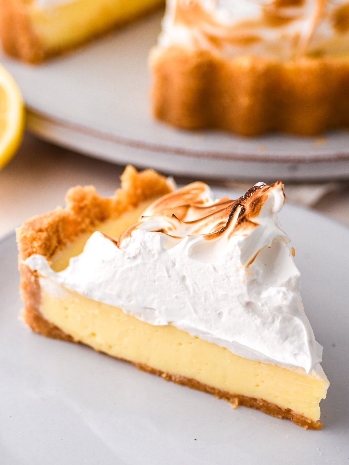 An up close image showing the perfect slice of lemon meringue pie. You can see how tall the meringue topping is.