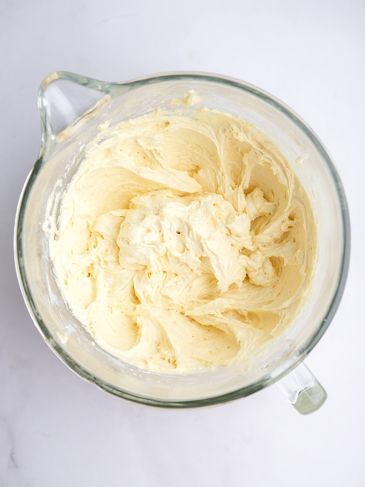 Image shows step 4 of how to make lemon drizzle cupcakes.