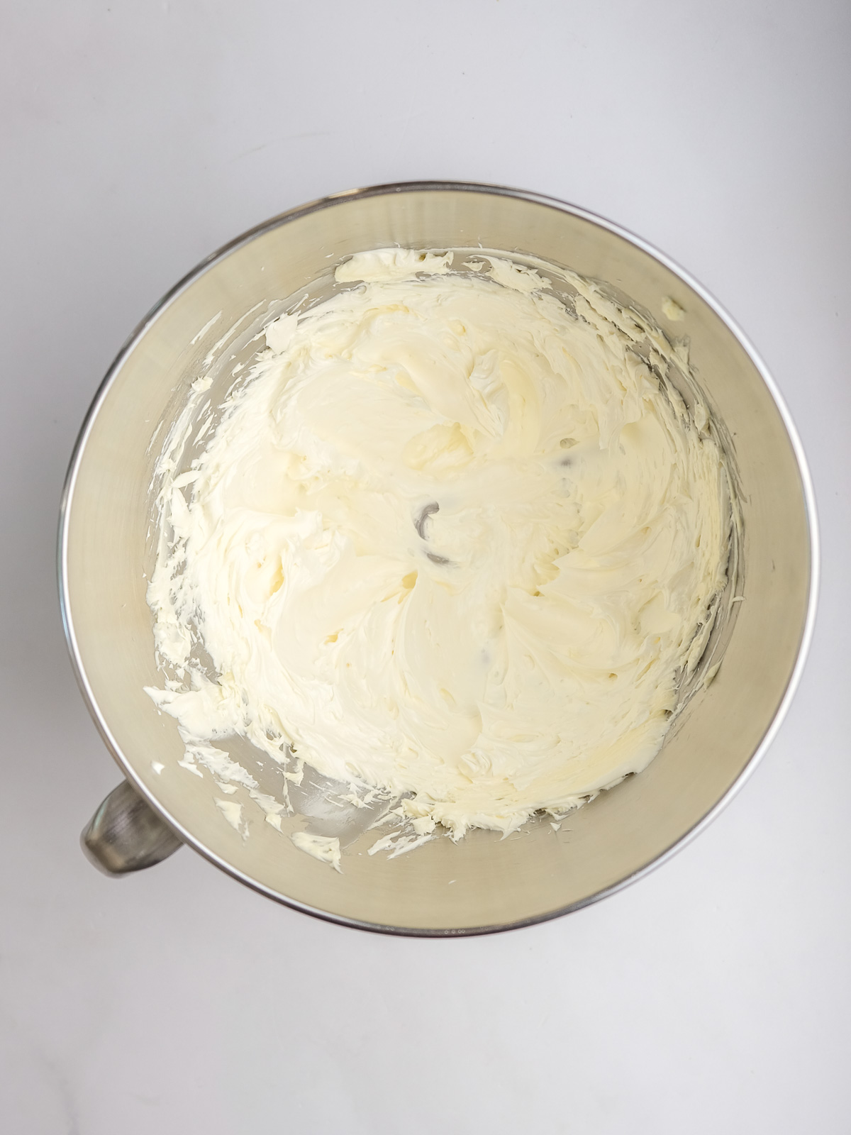 Image shows step 1 of how to make vanilla frosting for lemon drizzle cupcakes.