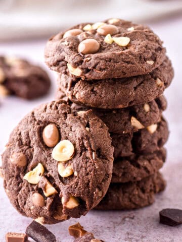 Hazelnut Chocolate Cookies shown stacked on a kitchen counter.