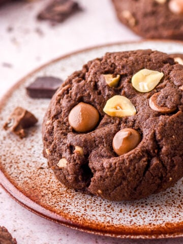 Hazelnut Chocolate Cookie shown on a speckled small plate. You can see the chocolate chips are still melted.