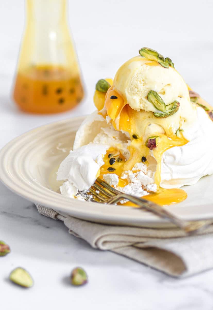 Mini Meringue nest shown filled with ice cream and mango slices.