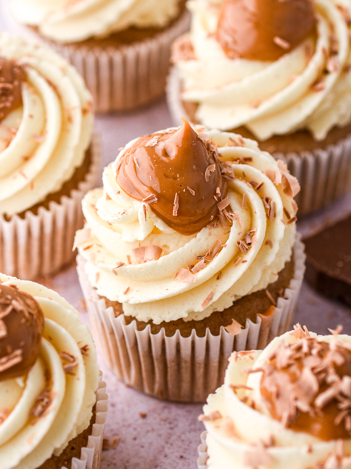 Banoffee Cupcakes shown on a kitchen counter, you can see the swirls of vanilla and caramel on the cupcakes.