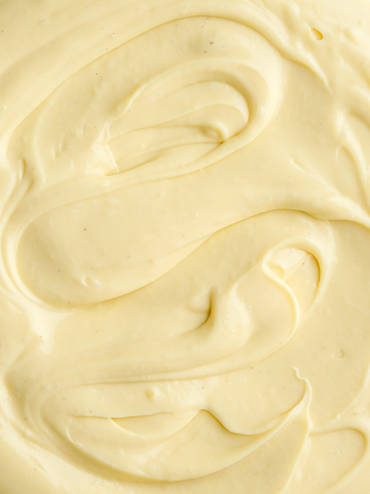 Vanilla Bean Custard shown up close, you can see the swirls of custard and the flecks of the seeds from the vanilla pod.