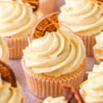 Image showing decorated orange cupcakes on a kitchen counter.