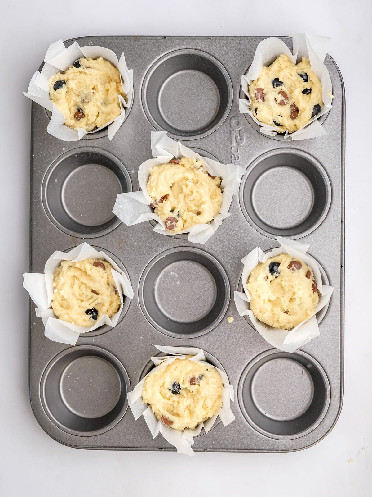Image shows step 5 of how to make blueberry chocolate chip muffins.