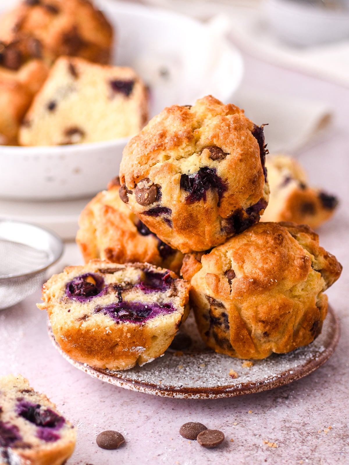 Blueberry and chocolate chip muffins shown piled high on a small plate.