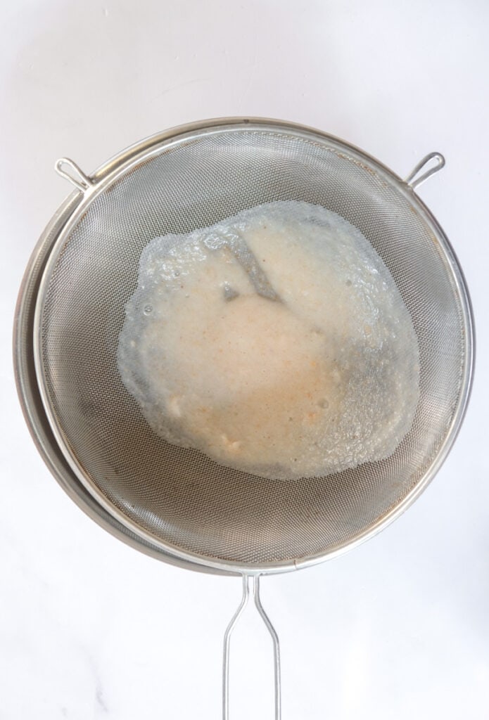 Image showing lychee juice being sieved. 