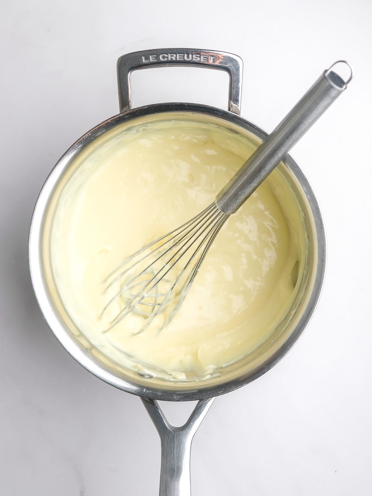 Image shows step 4 of how to make the milk tart layer of this desert.