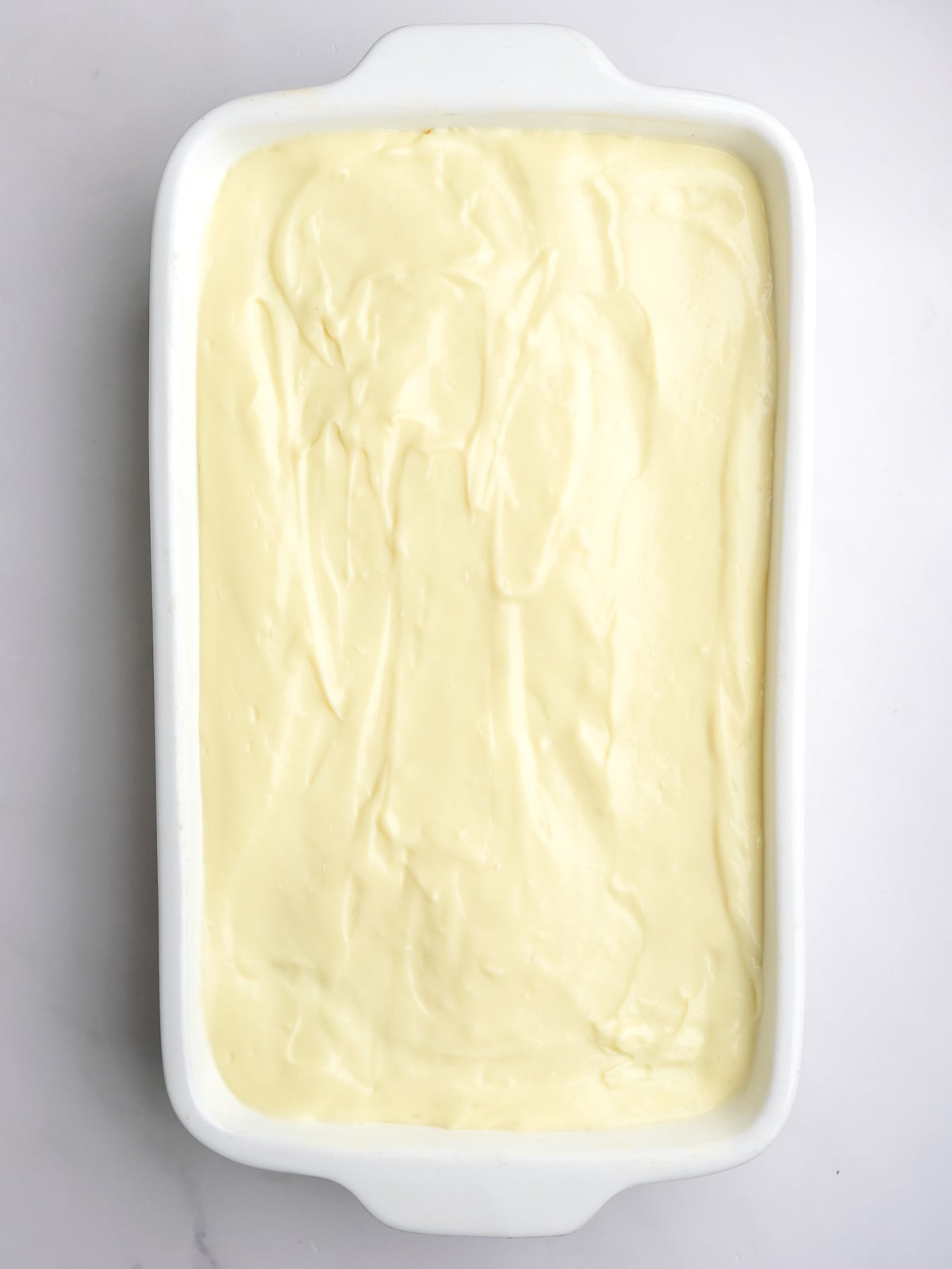 Image shows step 5 of how to make the milk tart layer of this desert.