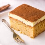 Image shows a slice of milktart malva pudding, you can see the moist malva and the creamy milktart layer.