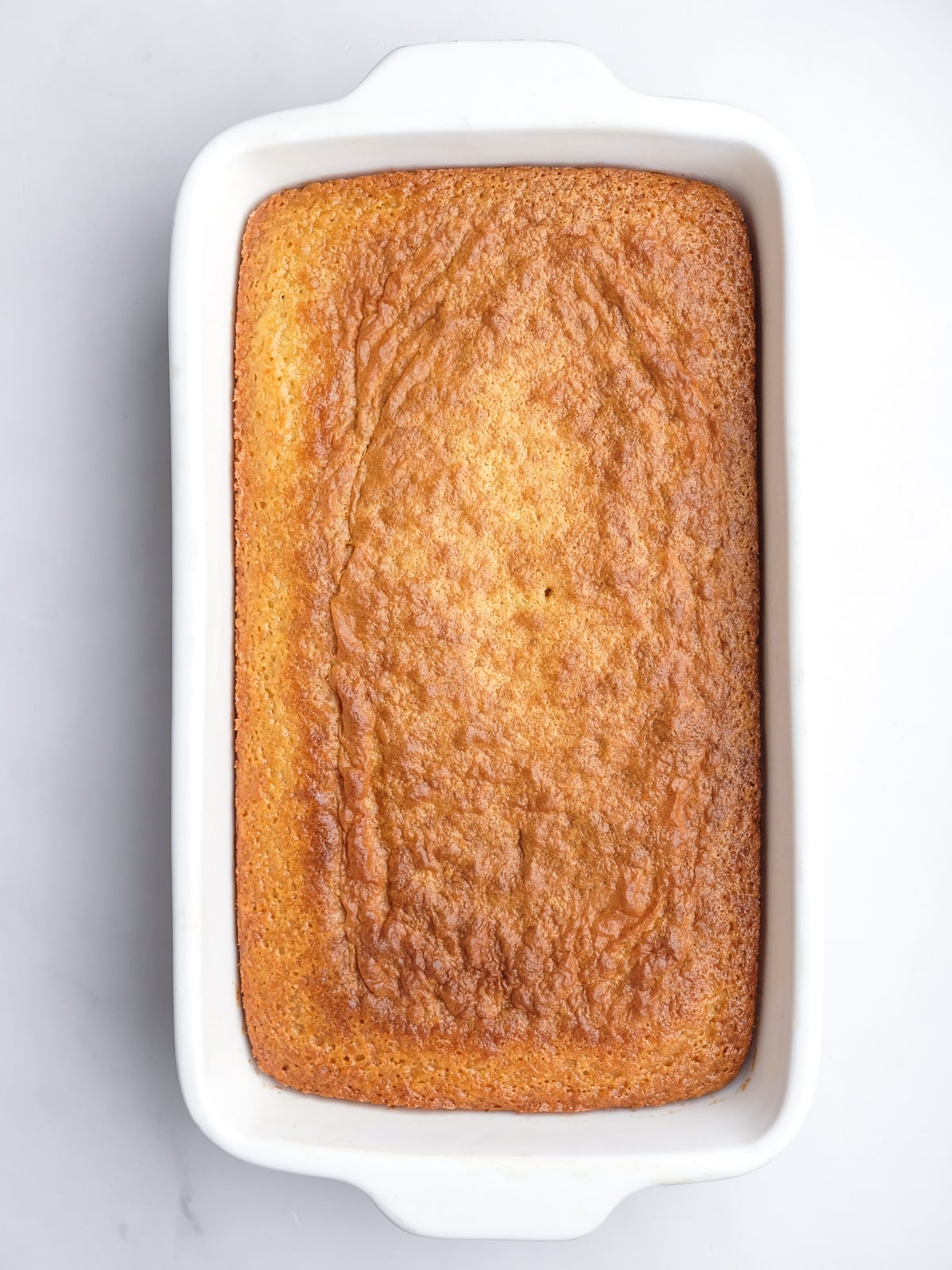 Image shows step 4 of how to make the malva pudding layer of this desert.
