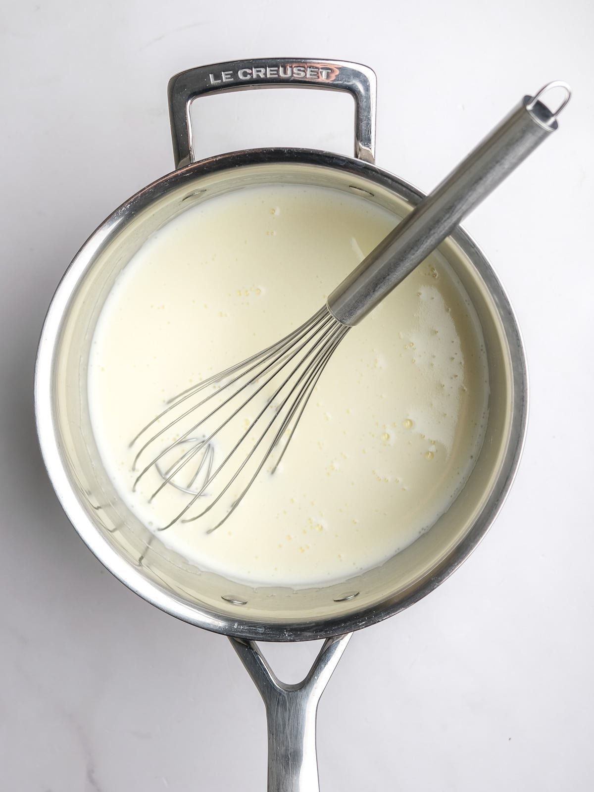 Image shows step 3 of how to make the milk tart layer of this desert.