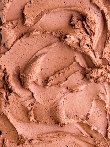 Whipped ganache frosting shown swirled over a flat surface.