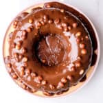 Chocolate Nut Cake shown from above, it is baked in a circular bundt cake tin and you can see the sauce dripped over the cake.