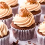 Dulce de leche cupcakes shown on a kitchen counter, each cupcake is decorated with a dollop of caramel on to top.