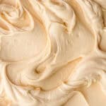 Dulce de Leche Frosting shown swirled on a flat surface.