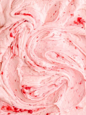 Raspberry Cream Cheese Frosting shown swirled, you can see the raspberry puree rippled through the frosting