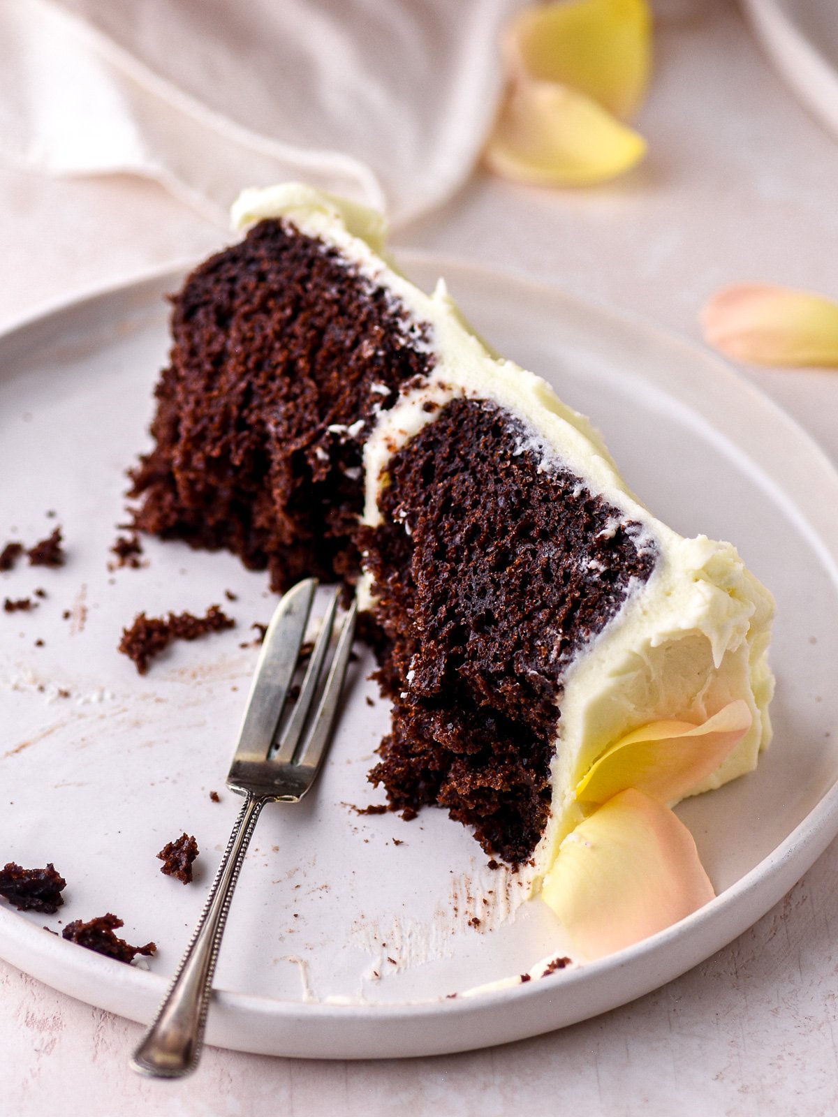 Image shows a half eaten slice of cake, you can see the moist dense texture of the cake.