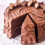 Image of a Bar One cake on a white cake plate. some slices have been cut.