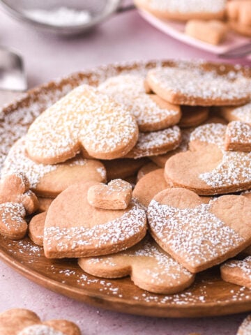 Heart shape cookies shown on a wooden plate.