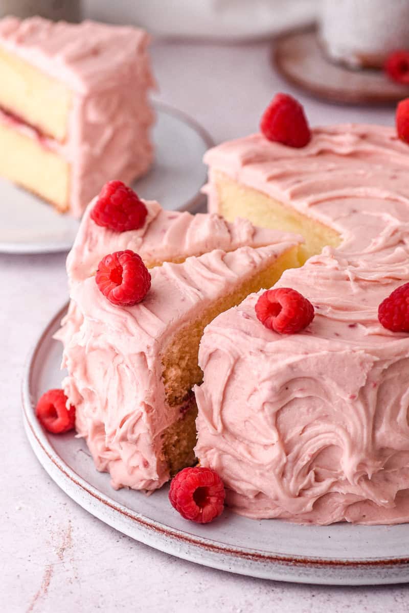Image showing the cake on a cake plate, three sliced have been cut. One can be seen in the background.