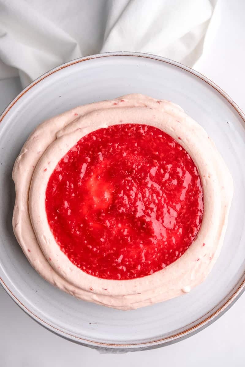 Image shows step 4 of how to make the raspberry cream cheese frosting.