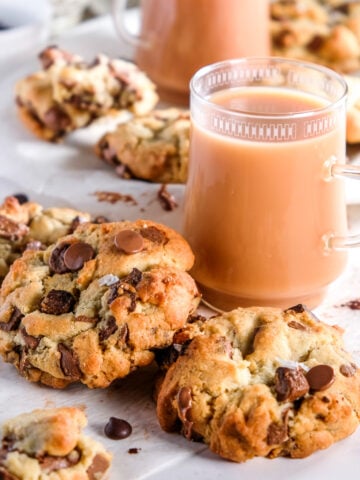Milk Chocolate Chunk Cookies shown next to two cups of tea.