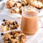Image shows the cookies on white parchment paper next to a mug of tea.