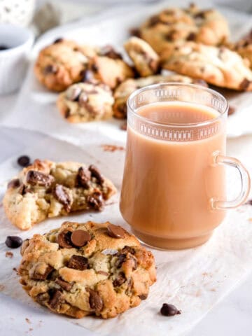 Image shows the cookies on white parchment paper next to a mug of tea.