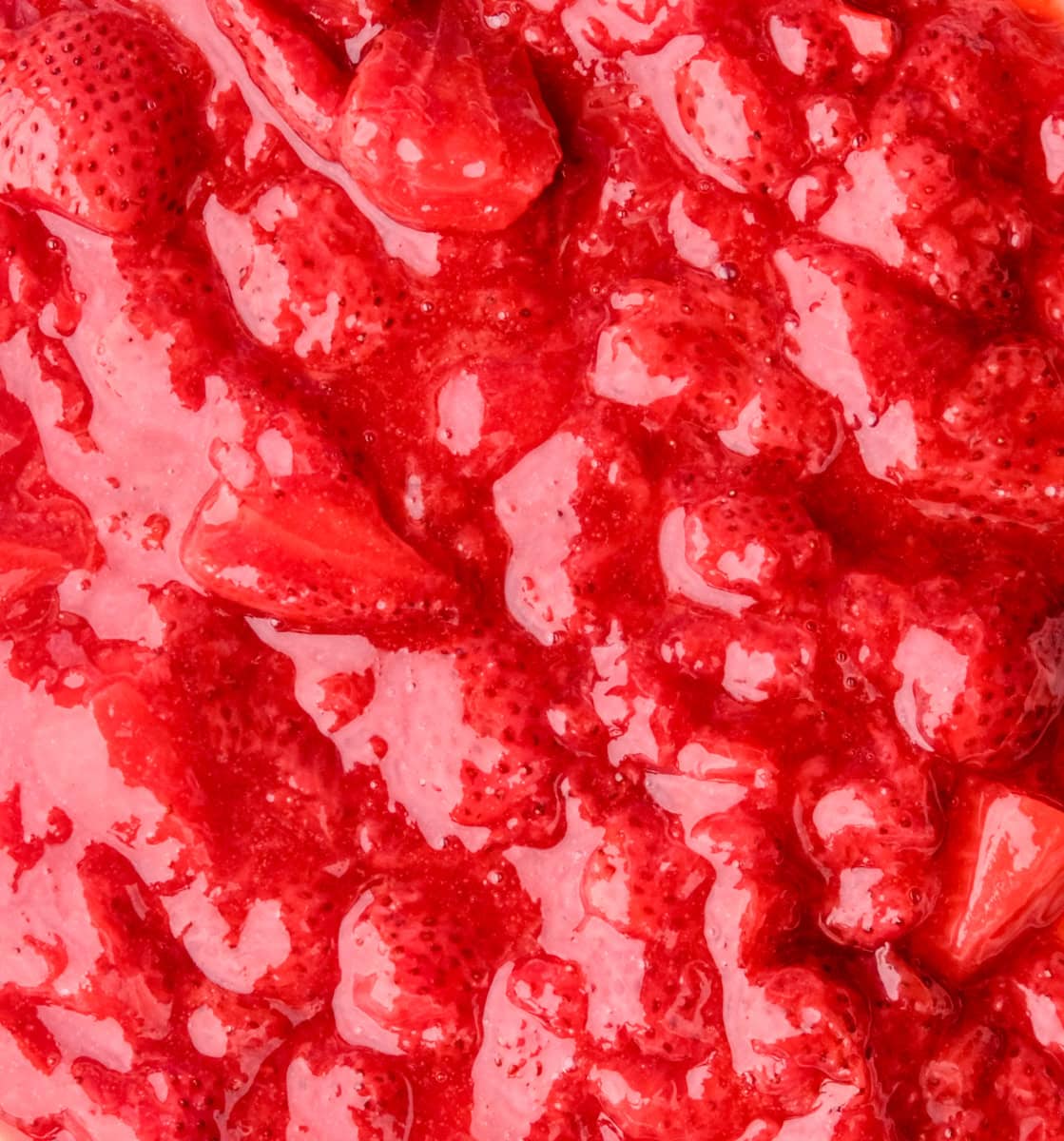 Image shows the filling up close, you can see the whole strawberries suspended in a thick strawberry sauce.