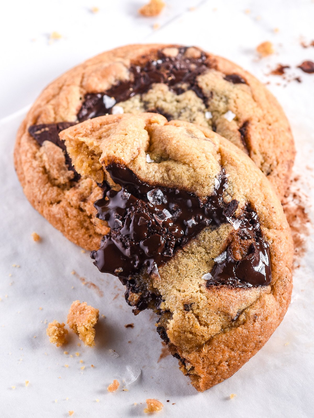 One and a half cookies shown on top of one another. You can see the sea salt and melted chocolate. 