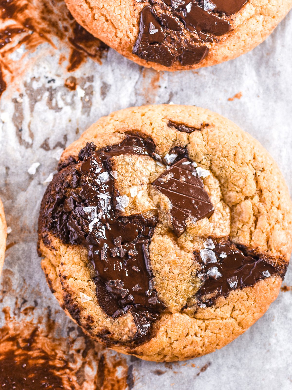 Bacon Grease Chocolate Chip Cookie shown from above on an over tray. You can see the melted pools of chocolate. 