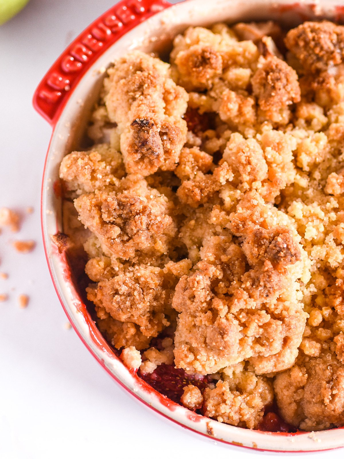 Image shows the baked crumble from above you can see the texture of the golden brown crumble. 