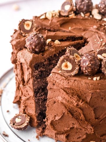 Image showing the whole cake on a cake plate, a slice has been cut.