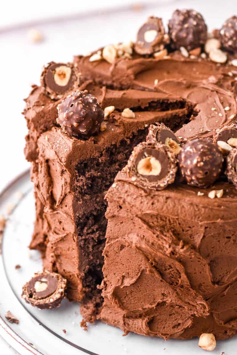 Image shows cake up close so that you can see the texture of the frosting and the Ferrero Rochers covering the top of the cake. 