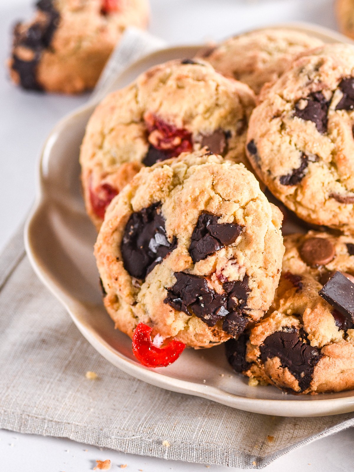 Image shows a plate filled with cookies, you can see their chunky texture and how filled they are with chocolate pieces.