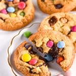 Smarties Cookies shown on a plate, one cookie has been broken in half.