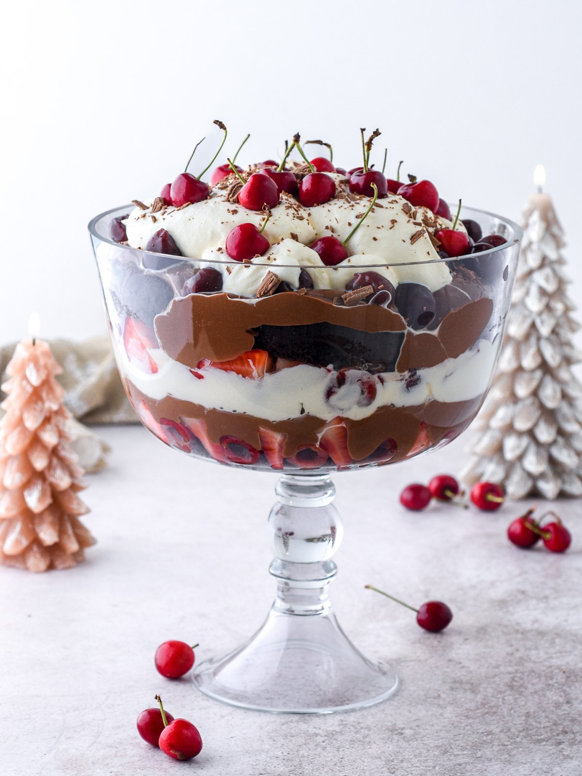 Black Forest Trifle shown in a glass trifle dish you can clearly see all the layers of the dessert.