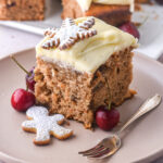 A slice of Christmas carrot sheet cake shown on a plate next to a fork.