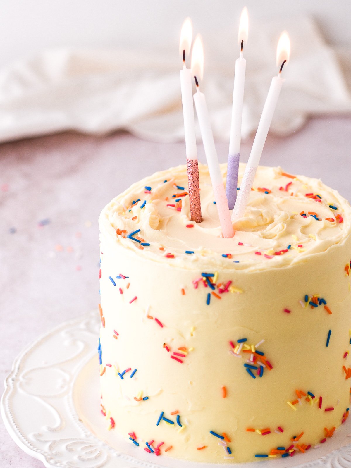 Image showing a vanilla birthday cake with sprinkles and candles.