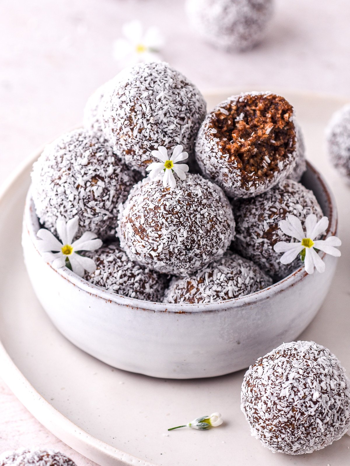 Image shows a small bowl filled with truffles dusted in desiccated coconut.