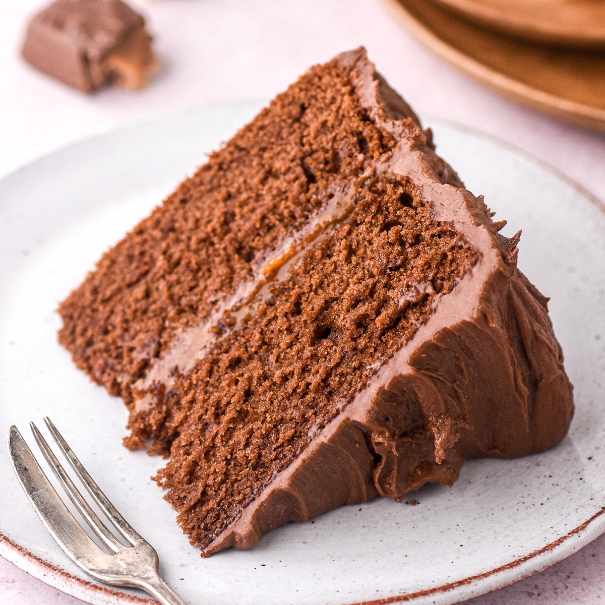 A slice of Bar One Chocolate caramel Cake show on a plate, it looks perfect.