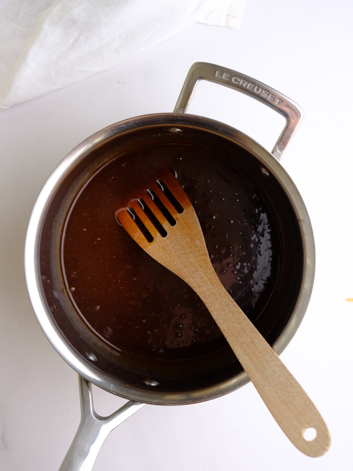 Image shows step 1 of how to make caramel glaze: the butter, dark brown sugar, and heavy cream boiling in a saucepan.