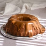 Apple Pecan Cake with Caramel Pecan Glaze shown on a flat cake plate.