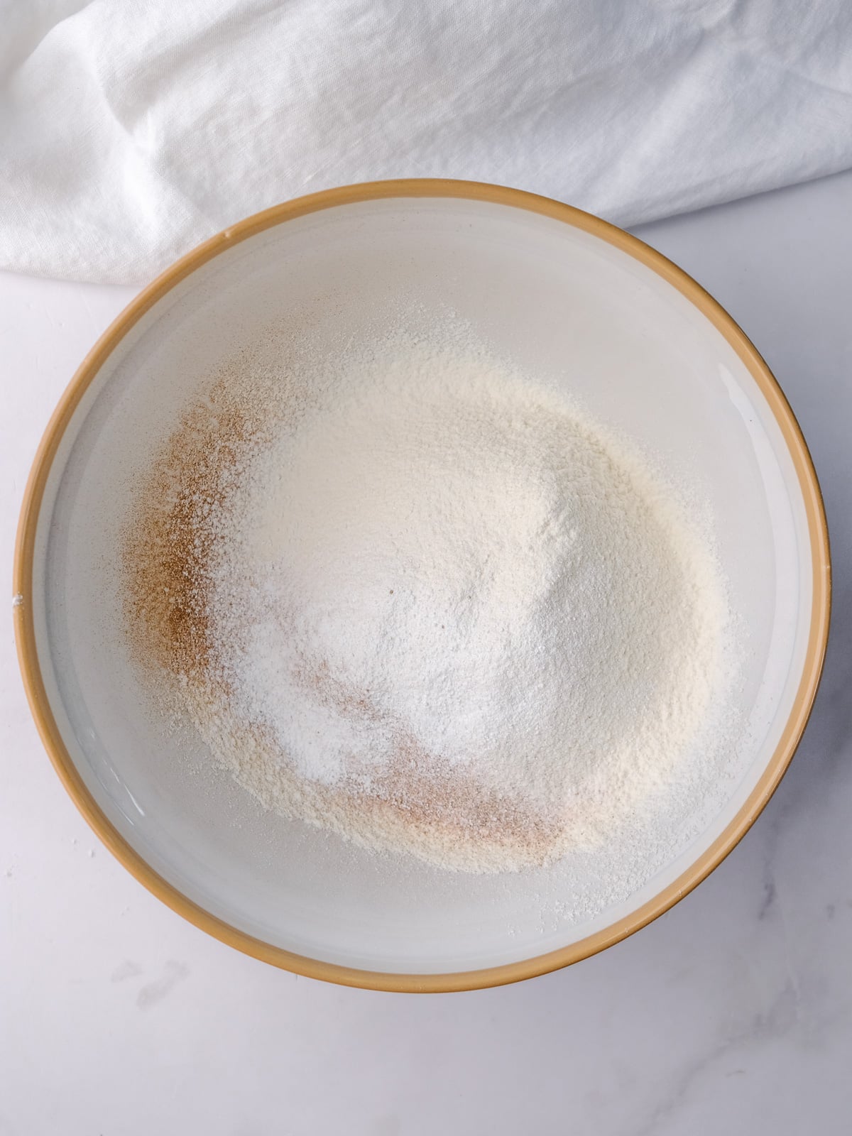 Image shows step 4 of how to make an apple and pecan cake: sift dry ingredients.