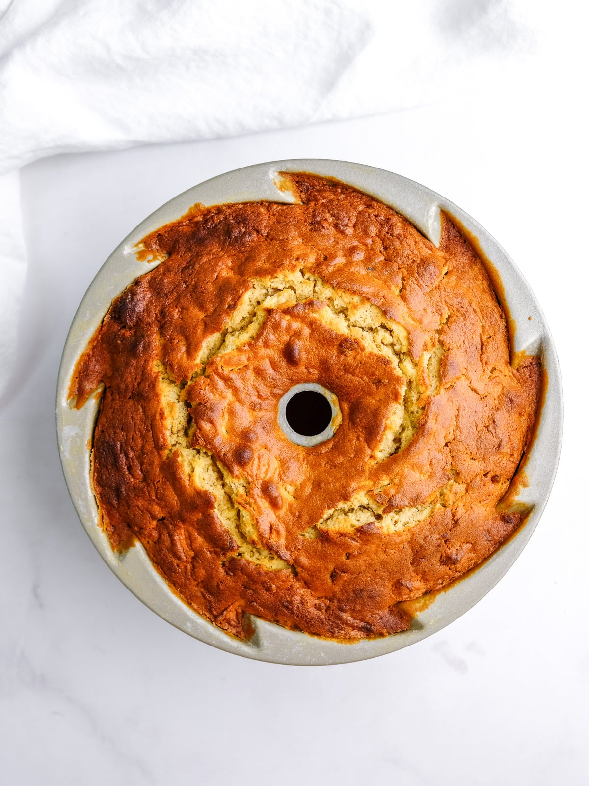 Image shows step 8 of how to make an apple and pecan cake: cool the cake in its tin before turning it out onto a plate.