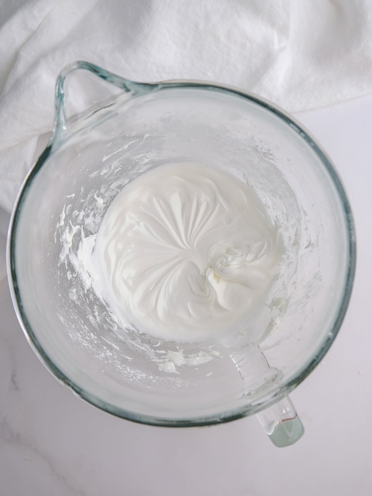 Image shows step 2 of how to make royal icing to decorate chocolate gingerbread cookies.